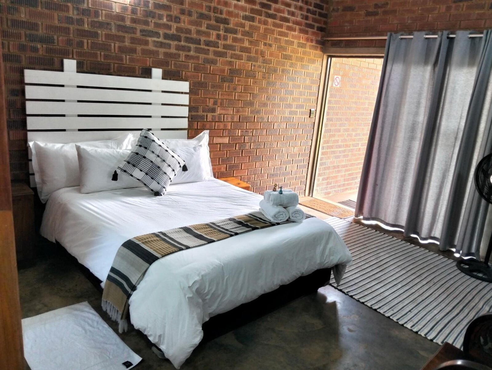 Queen bed in a face-brick room